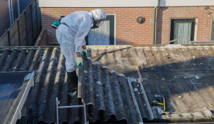 A person cleaning asbestos waste