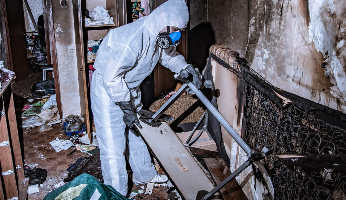 A person cleaning a fire-damaged room