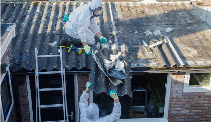 The person is removing asbestos roofing sheets