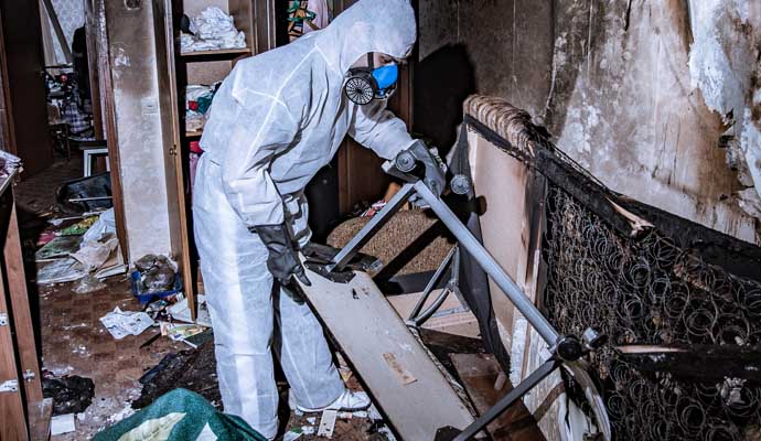 Person cleaning burned waste in a room