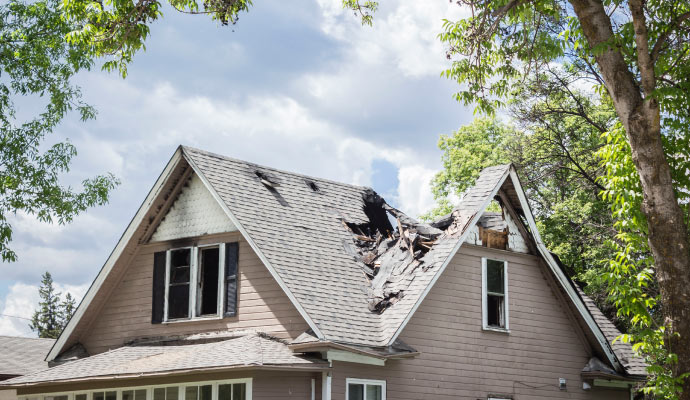 A house with a severely damaged roof from a fire