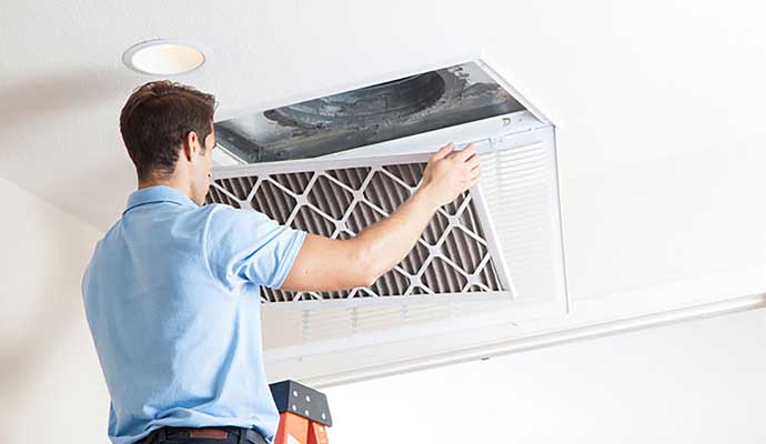 Technician replacing an air duct filter