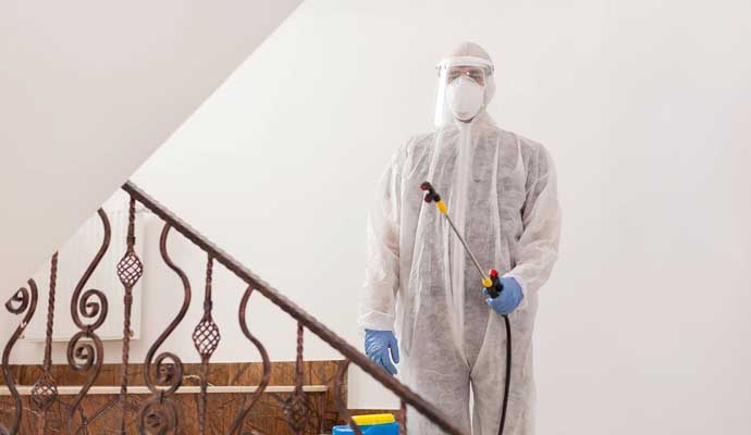 A person disinfecting an indoor area with equipment