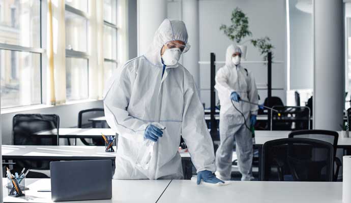 A person sanitizing an office space