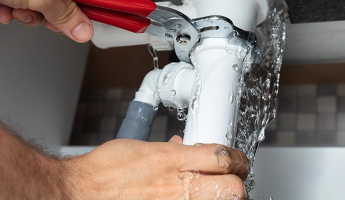 Person repairing water pipe with equipment